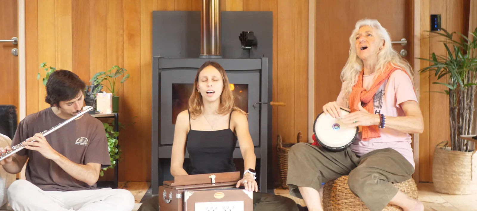 Kirtan con flauta, armonio y tambor junto a la estufa a leña