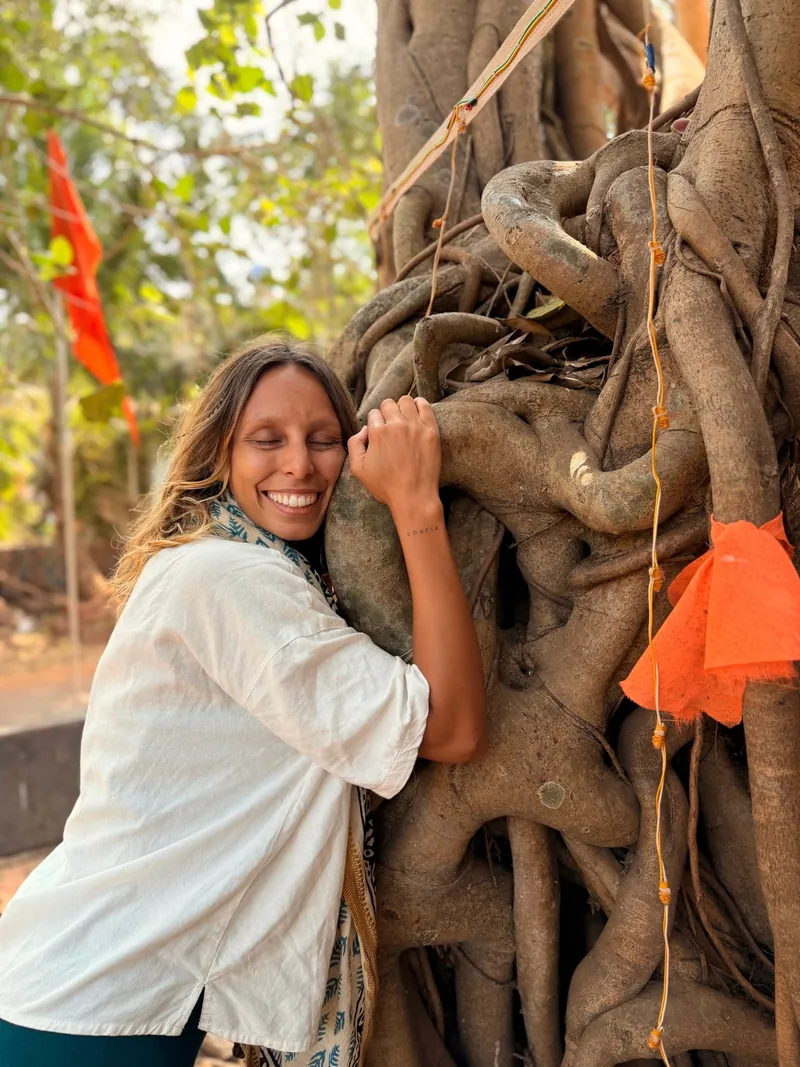 Vivi abrazando un árbol, sonriendo